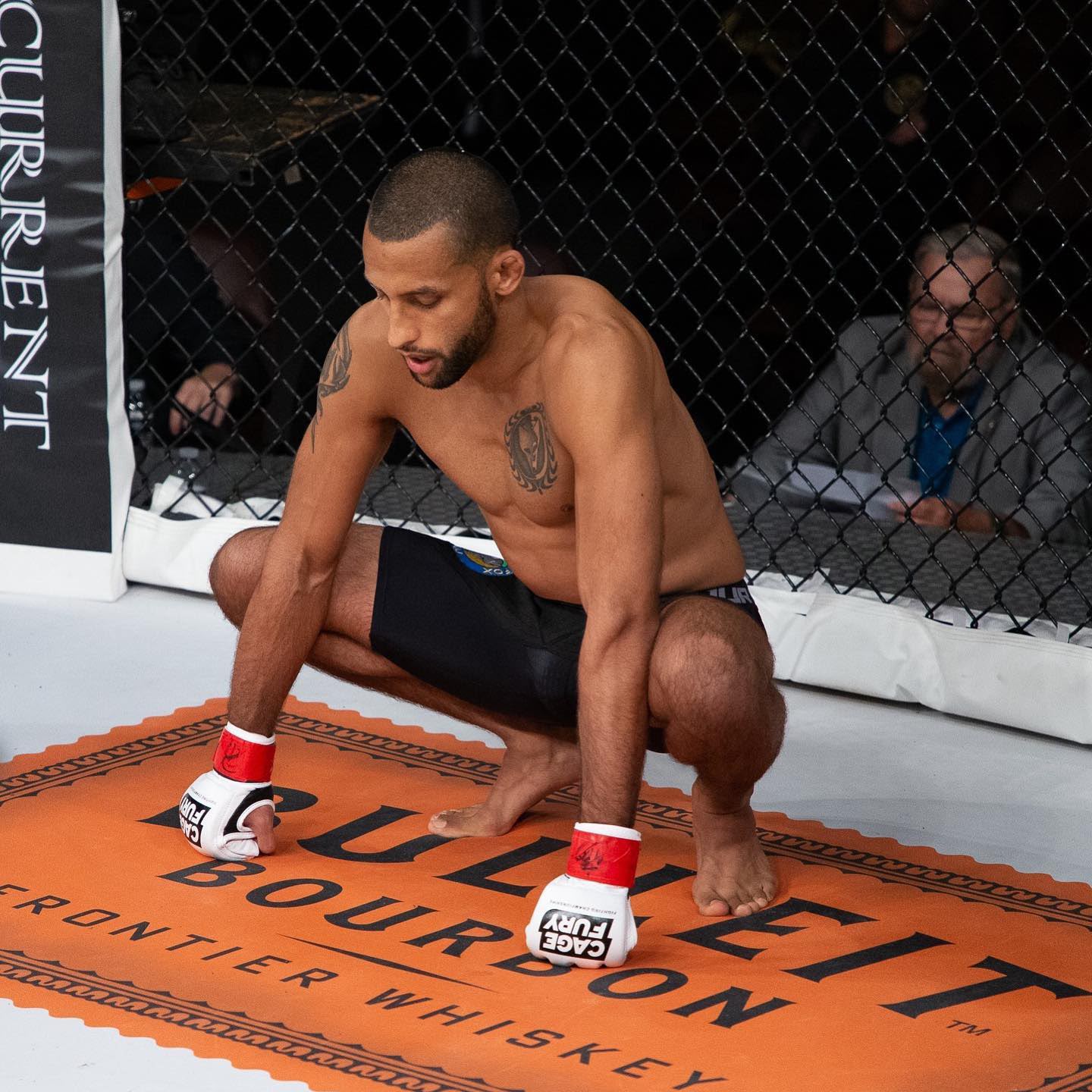 Fighter kneeling in the cage, taking a breath